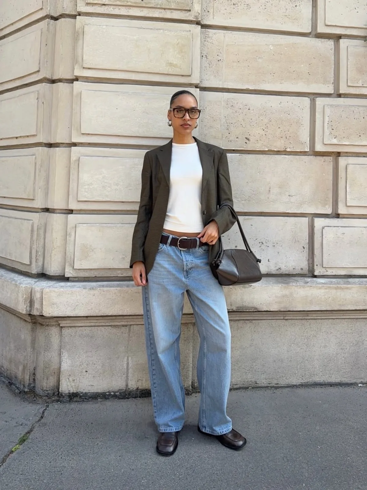 Minimalistyczna stylizacja street style z oversize’ową marynarką, jasnymi jeansami i klasyczną torebką. Estetyka quiet luxury i modne basic pieces nawiązują do stylu, z którego przez lata słynął Topshop.