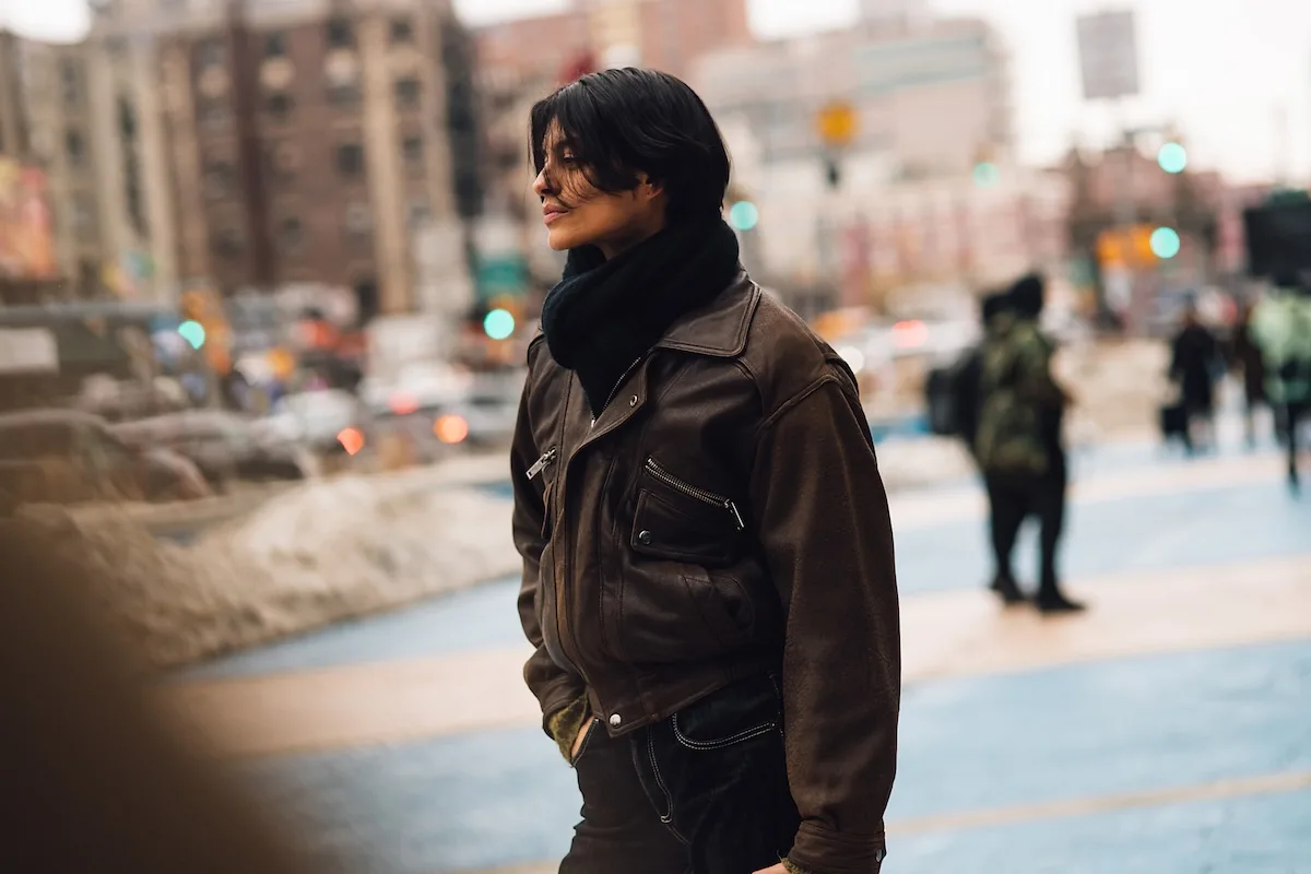 Kobieta w skórzanej kurtce na tle miejskiej ulicy, w stylu streetwear, symbolizująca współczesną modę miejską. W kontekście nowych przepisów UE dotyczących pracy przymusowej rośnie presja na producentów odzieży, by kontrolować pochodzenie materiałów i produkcji. Regulacje wpływają na cały rynek – od projektantów po globalne łańcuchy dostaw.