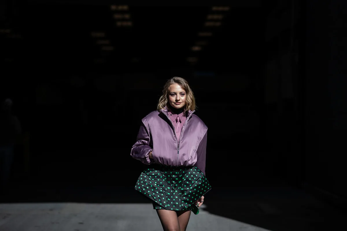 Wartość rynku fast fashion do roku 2032. Modelka w awangardowej stylizacji ukazująca śmiałe połączenie barw i krojów – typowe dla fast fashion. Błyskawiczne reagowanie na tendencje i krótkie serie produkcyjne są fundamentalne dla ekspansji branży odzieżowej. Fotografia ilustruje dynamikę i innowacyjność, które pobudzają globalny obszar fast fashion.