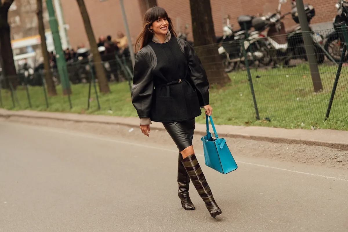 ASOS sklep stacjonarny. Kobieta w czarnej stylizacji streetwearowej spaceruje ulicą z turkusową torbą w dłoni. Zdjęcie ilustruje modę miejską i rosnące znaczenie sprzedaży stacjonarnej w strategii internetowych marek fashion.