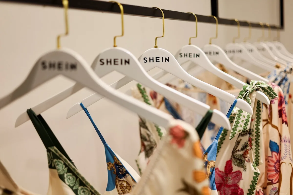 Ubrania marki Shein zawieszone na firmowych wieszakach. Francja nałożyła na chińskiego giganta ultra fast fashion ponad 22 mln euro kar za naruszenia praw konsumentów i brak wymaganych informacji dotyczących produktów oraz marketplace’u.