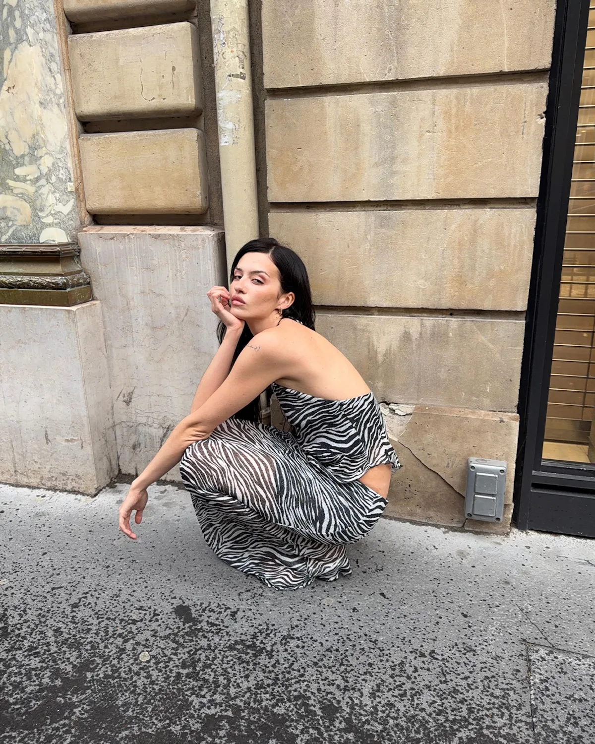 Street style w zwierzęcy wzór sfotografowany podczas tygodnia mody. W czasie letnich wyprzedaży 2026 podobne modele sukienek można znaleźć w ofertach marek takich jak Zara, Mango czy Reserved.