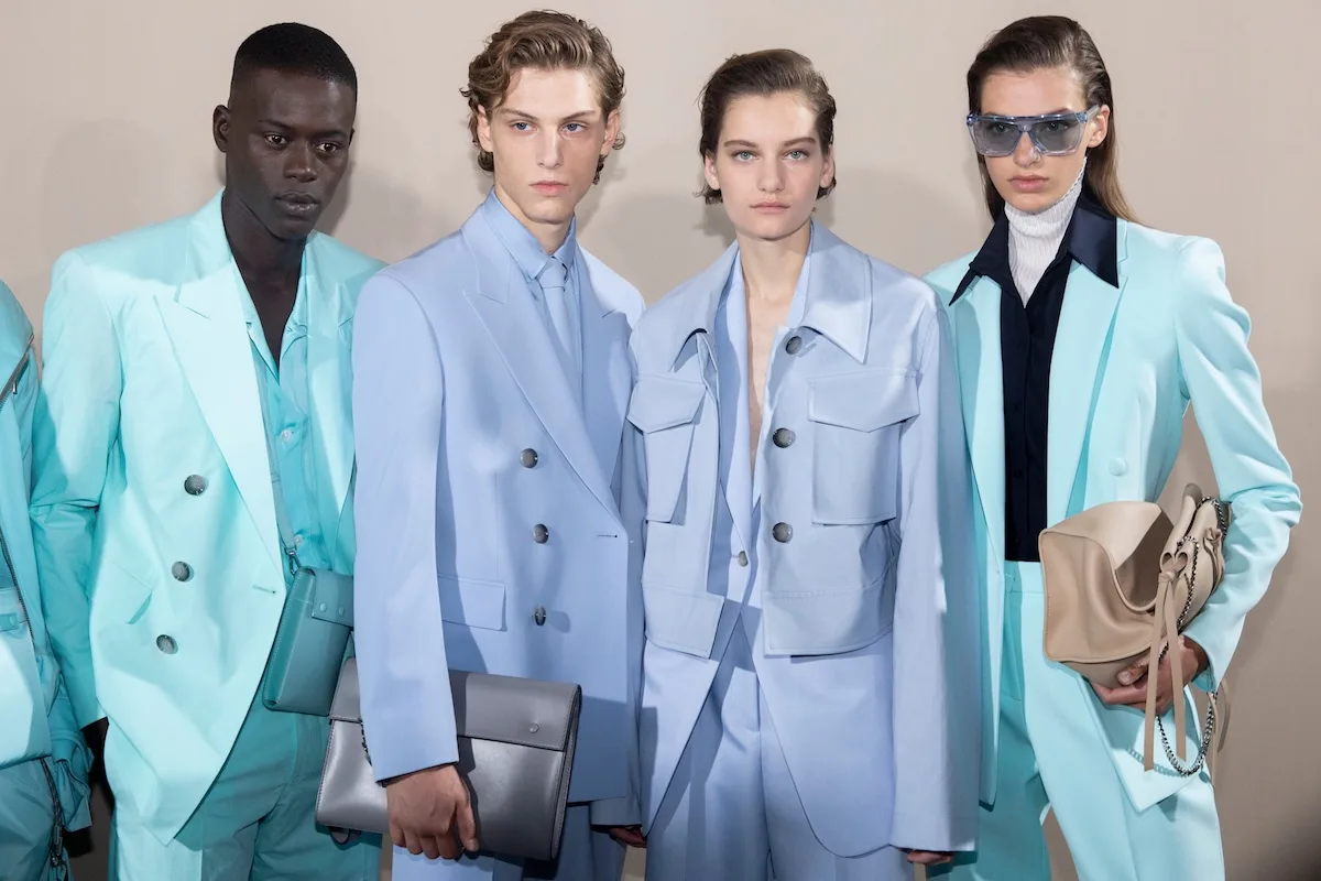 Modele w pastelowych garniturach i marynarkach Hugo Boss pozują za kulisami pokazu, nawiązując do modowego DNA niemieckiej marki i jej silnej pozycji w segmencie eleganckiej odzieży.