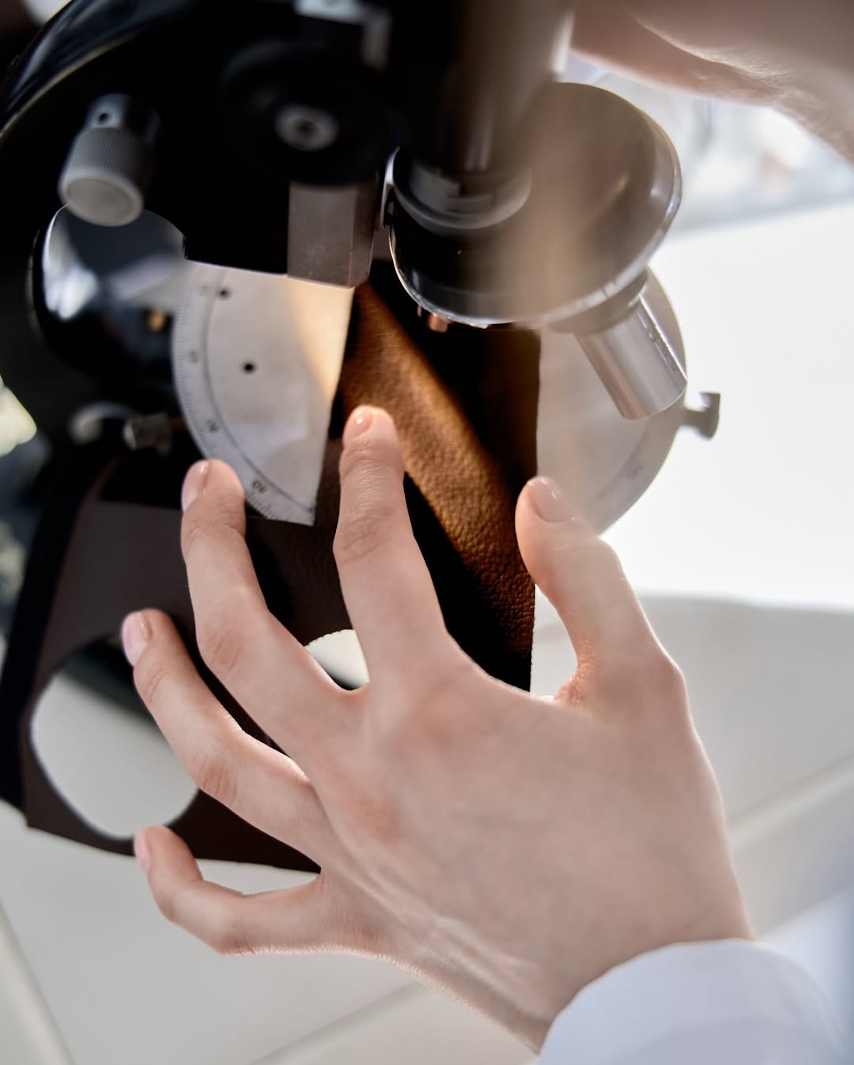 Badanie próbki materiału NUTICO® w laboratorium, z widoczną strukturą przypominającą skórę naturalną. Zdjęcie pokazuje testy polskiej „czekoladowej skóry” stworzonej z łusek kakaowca i łupin orzechów.